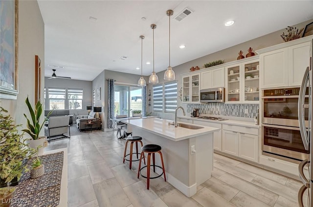 9940 Heather Moore Ave, Las Vegas, NV 89166 - kitchen featuring stainless steel appliances, a ceiling fan, white cabinets, tasteful backsplash, and recessed lighting