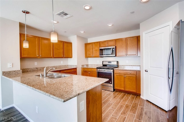 3116 Paladi Ave, Henderson, NV 89044 - kitchen with appliances with stainless steel finishes, a peninsula, light wood-type flooring, brown cabinets, and recessed lighting