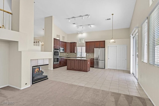20 Staghorn St, Henderson, NV 89012 - kitchen with stainless steel appliances, light carpet, light tile patterned floors, a center island, and a towering ceiling