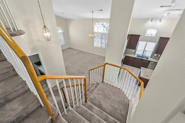 20 Staghorn St, Henderson, NV 89012 - stairway with carpet floors, a chandelier, and track lighting