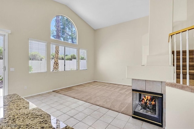 20 Staghorn St, Henderson, NV 89012 - unfurnished living room featuring light carpet, light tile patterned floors, healthy amount of natural light, stairway, and high vaulted ceiling