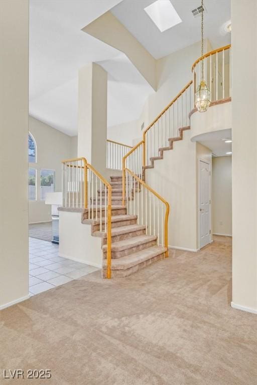20 Staghorn St, Henderson, NV 89012 - staircase featuring a skylight, carpet, a high ceiling, and tile patterned floors
