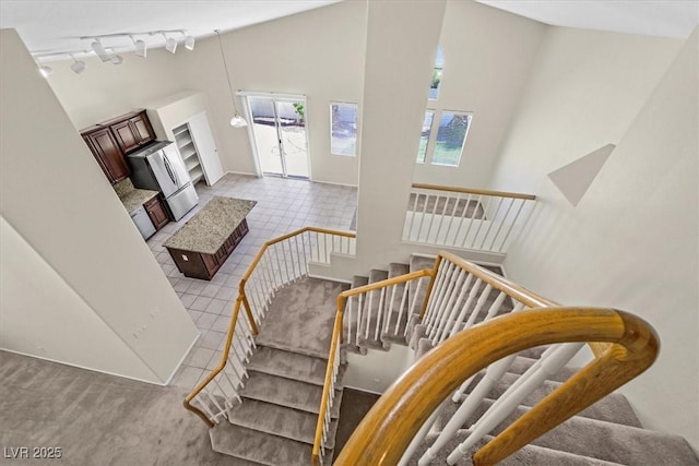 20 Staghorn St, Henderson, NV 89012 - staircase with healthy amount of natural light, track lighting, tile patterned flooring, and a towering ceiling