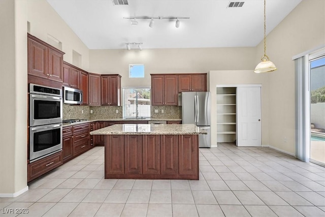 20 Staghorn St, Henderson, NV 89012 - kitchen featuring stainless steel appliances, tasteful backsplash, a kitchen island, and healthy amount of natural light