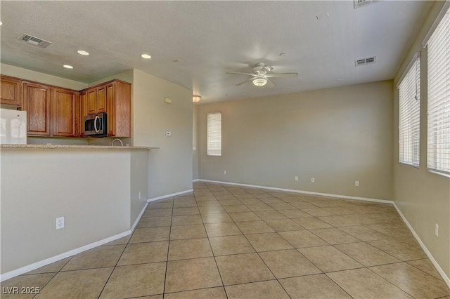 4505 Truscott Ct, Las Vegas, NV 89130 - kitchen featuring stainless steel microwave, a ceiling fan, recessed lighting, refrigerator, and light tile patterned flooring