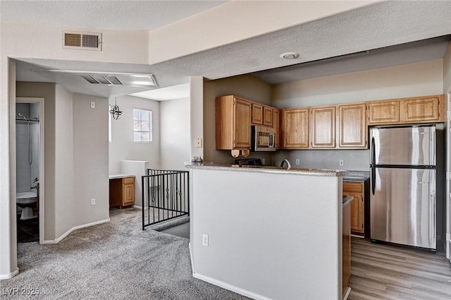 8555 W Russell Rd Unit 2015, Las Vegas, NV 89113 - kitchen with appliances with stainless steel finishes, a peninsula, and light carpet