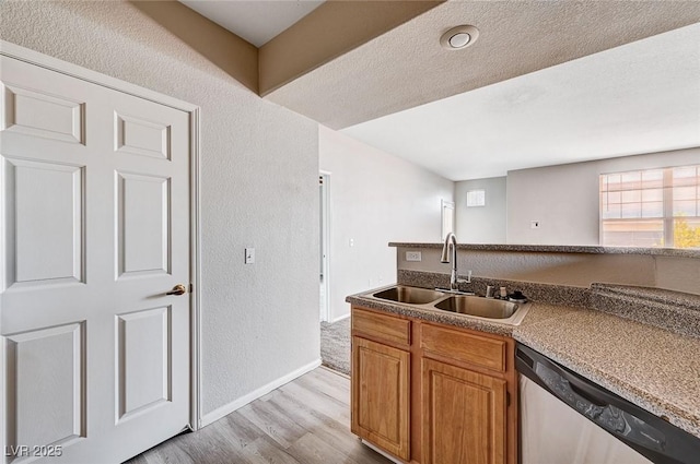 8555 W Russell Rd Unit 2015, Las Vegas, NV 89113 - kitchen with dishwasher, light wood-style flooring, a textured wall, and brown cabinetry