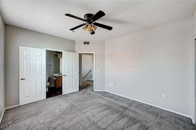 8555 W Russell Rd Unit 2015, Las Vegas, NV 89113 - unfurnished bedroom with dark carpet, ensuite bathroom, ceiling fan, and a textured ceiling