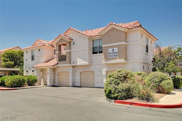 8555 W Russell Rd Unit 2015, Las Vegas, NV 89113 - view of front of house with a tile roof, a garage, stucco siding, and driveway