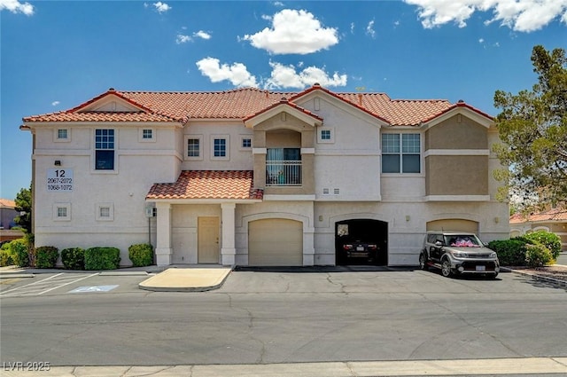 8555 W Russell Rd Unit 2015, Las Vegas, NV 89113 - view of front of house with a tiled roof, stucco siding, a garage, and driveway
