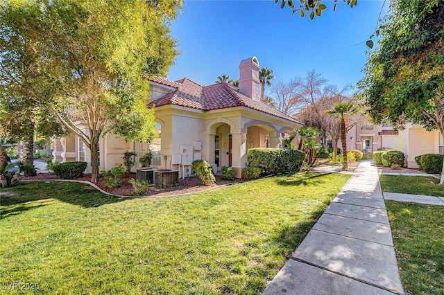 8555 W Russell Rd Unit 2015, Las Vegas, NV 89113 - mediterranean / spanish house with a chimney, a front lawn, stucco siding, and a tiled roof