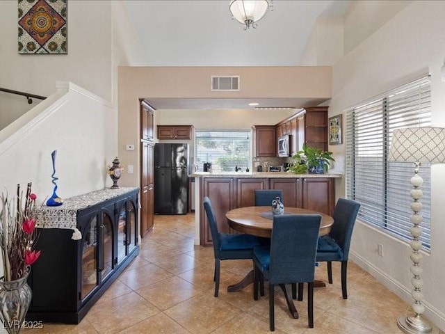 8961 Clairton Ct, Las Vegas, NV 89117 - dining room with healthy amount of natural light, a high ceiling, and light tile patterned floors