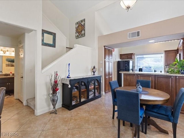 8961 Clairton Ct, Las Vegas, NV 89117 - dining area featuring high vaulted ceiling, stairway, and light tile patterned floors