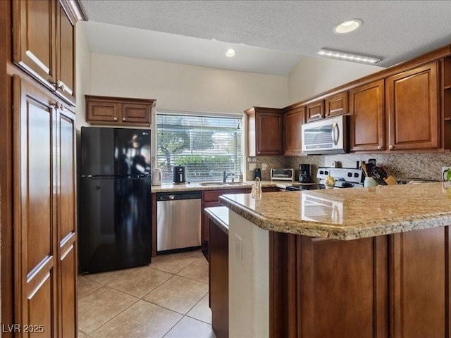 8961 Clairton Ct, Las Vegas, NV 89117 - kitchen featuring stainless steel appliances, a peninsula, decorative backsplash, light tile patterned floors, and recessed lighting