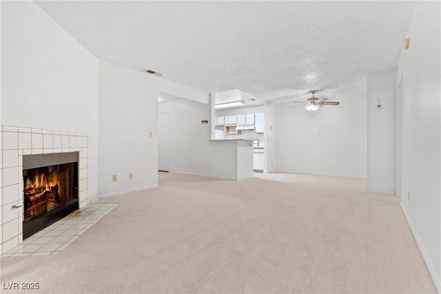 2200 S Fort Apache Rd Unit 1114, Las Vegas, NV 89117 - unfurnished living room with a ceiling fan, light colored carpet, a tiled fireplace, and a textured ceiling