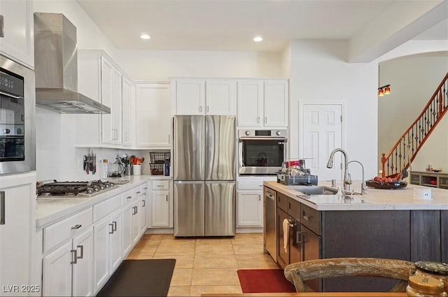 10500 Eagle Nest St, Las Vegas, NV 89141 - kitchen with appliances with stainless steel finishes, wall chimney exhaust hood, light countertops, white cabinetry, and light tile patterned flooring