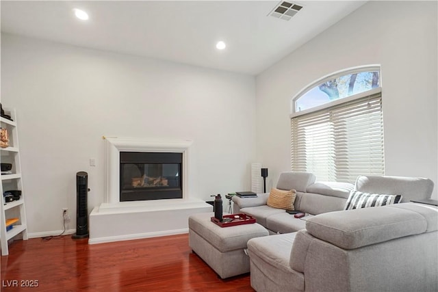 10500 Eagle Nest St, Las Vegas, NV 89141 - living area featuring wood finished floors, a glass covered fireplace, recessed lighting, and vaulted ceiling