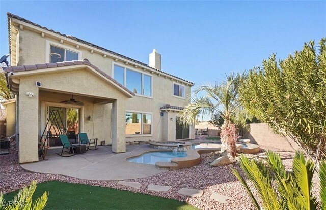 10500 Eagle Nest St, Las Vegas, NV 89141 - back of property with ceiling fan, a chimney, a patio area, stucco siding, and a pool with connected hot tub