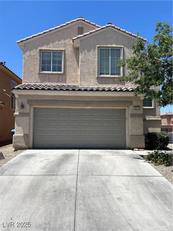 4013 Kindhearted Ct, North Las Vegas, NV 89032 - traditional-style home featuring an attached garage, a tiled roof, driveway, and stucco siding