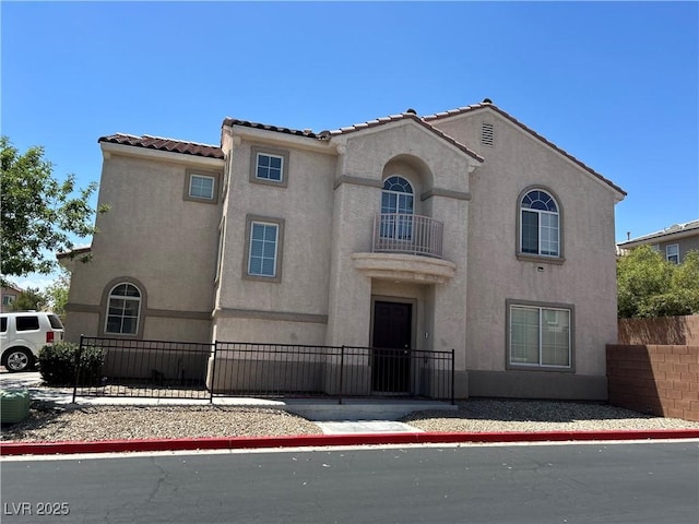 4013 Kindhearted Ct, North Las Vegas, NV 89032 - mediterranean / spanish-style home featuring stucco siding, a fenced front yard, a balcony, and a tiled roof