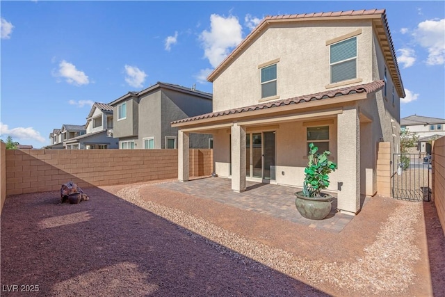 7104 Stockton Dunes St, North Las Vegas, NV 89084 - rear view of property featuring stucco siding, a patio, a fenced backyard, a tile roof, and a gate