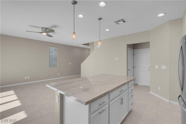 7104 Stockton Dunes St, North Las Vegas, NV 89084 - kitchen featuring ceiling fan, a kitchen island, light tile patterned floors, recessed lighting, and decorative light fixtures
