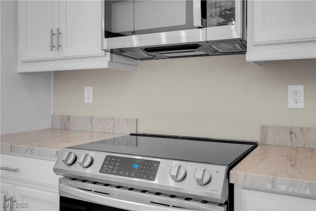 7104 Stockton Dunes St, North Las Vegas, NV 89084 - kitchen with appliances with stainless steel finishes, white cabinetry, and light stone counters