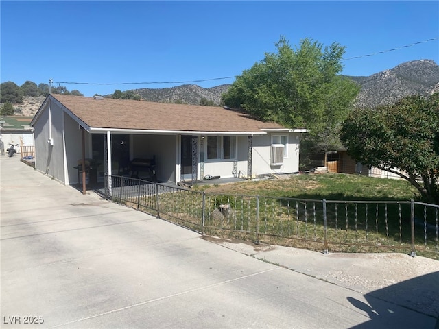 27 Carson Ct, Ely, NV 89301 - view of front of house with a fenced front yard, covered porch, a mountain view, and a carport