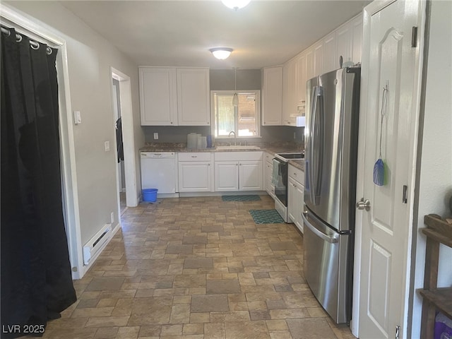27 Carson Ct, Ely, NV 89301 - kitchen featuring white appliances, white cabinetry, stone finish floors, and baseboard heating