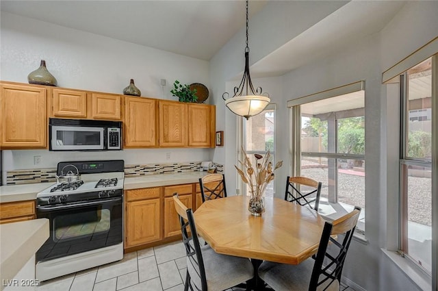 1734 Marshall Dr, Henderson, NV 89014 - kitchen with stainless steel microwave, gas range oven, light countertops, light tile patterned floors, and vaulted ceiling