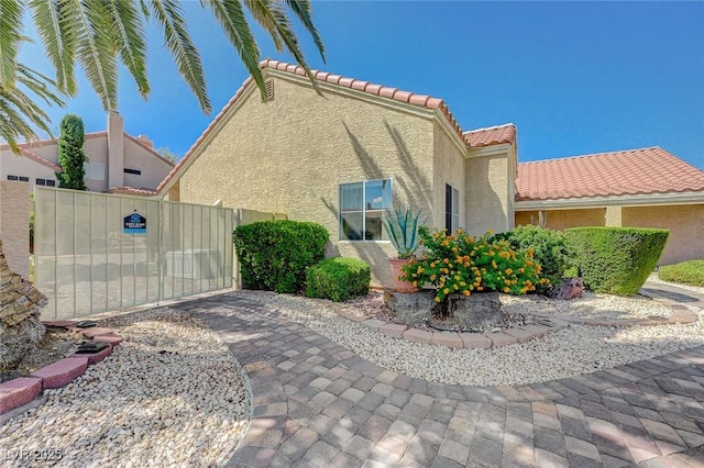 1734 Marshall Dr, Henderson, NV 89014 - view of property exterior featuring stucco siding, a gate, and a tile roof