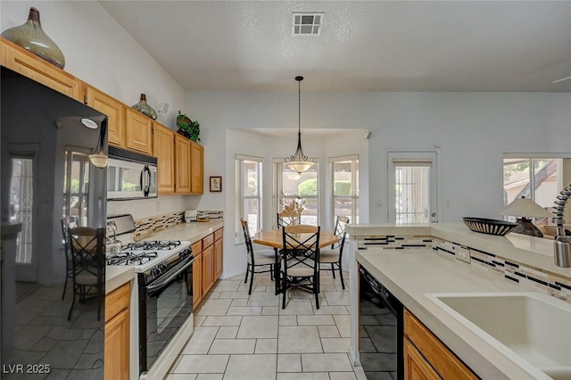 1734 Marshall Dr, Henderson, NV 89014 - kitchen with fridge, gas range gas stove, dishwasher, light countertops, and hanging light fixtures