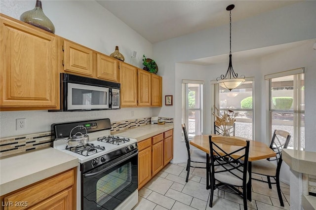 1734 Marshall Dr, Henderson, NV 89014 - kitchen featuring stainless steel microwave, gas range, tasteful backsplash, light countertops, and light tile patterned flooring