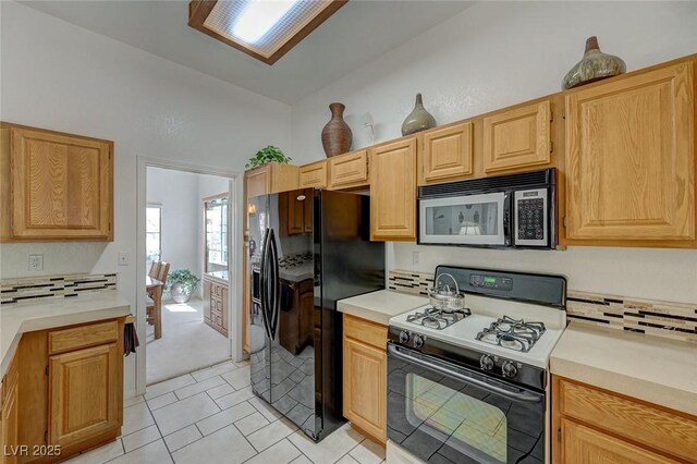 1734 Marshall Dr, Henderson, NV 89014 - kitchen featuring black appliances, light countertops, light tile patterned floors, and light brown cabinetry