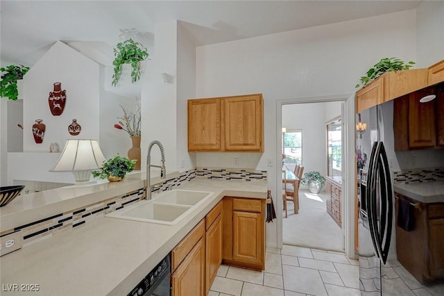 1734 Marshall Dr, Henderson, NV 89014 - kitchen featuring light tile patterned floors, tasteful backsplash, light countertops, and black fridge