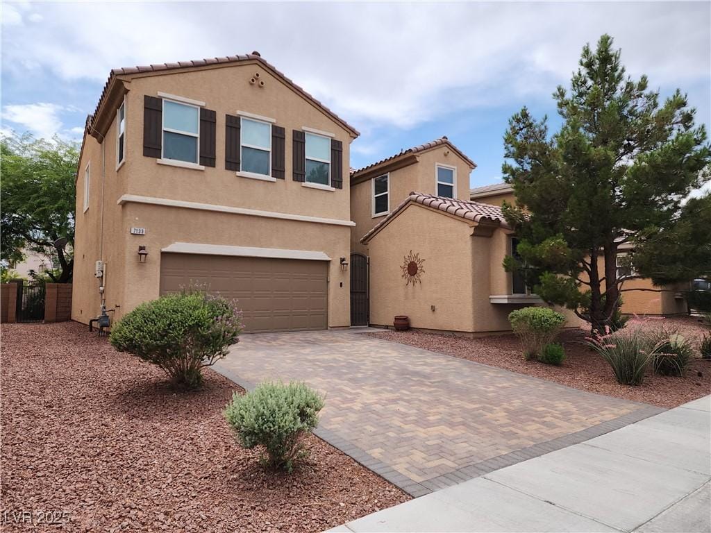 7133 Weavers Pl, North Las Vegas, NV 89084 - view of front of house featuring decorative driveway, stucco siding, a garage, a tiled roof, and a gate