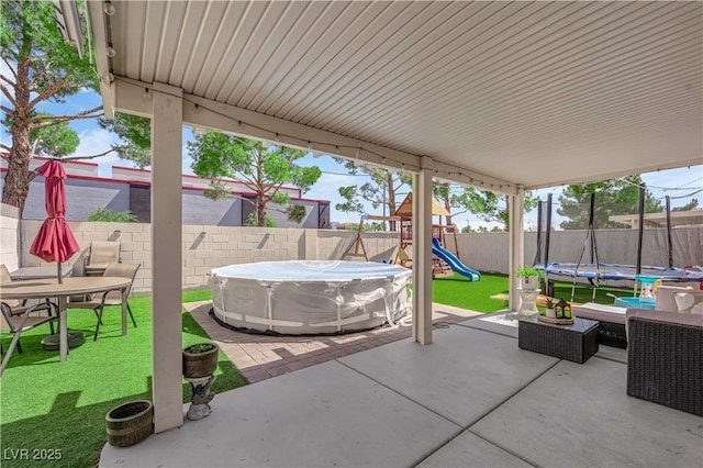 7316 Young Doe Ave, Las Vegas, NV 89130 - fenced backyard with a trampoline, a patio area, a playground, and outdoor dining space