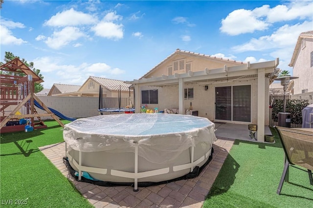 7316 Young Doe Ave, Las Vegas, NV 89130 - back of house featuring a playground, a trampoline, a pergola, stucco siding, and a patio area