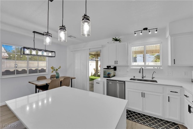 7316 Young Doe Ave, Las Vegas, NV 89130 - kitchen featuring stainless steel dishwasher, healthy amount of natural light, light wood finished floors, and light countertops