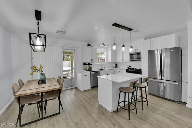 7316 Young Doe Ave, Las Vegas, NV 89130 - kitchen with appliances with stainless steel finishes, light wood-style flooring, light countertops, and white cabinets