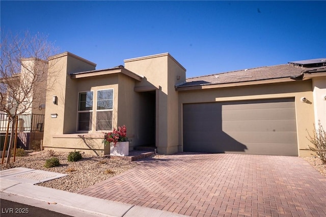 9584 Jadeite Ln, Las Vegas, NV 89143 - view of front of property with decorative driveway, an attached garage, and stucco siding