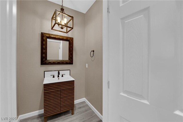 8520 Insignia Ave Unit 104, Las Vegas, NV 89178 - bathroom with vanity, wood finished floors, and a chandelier