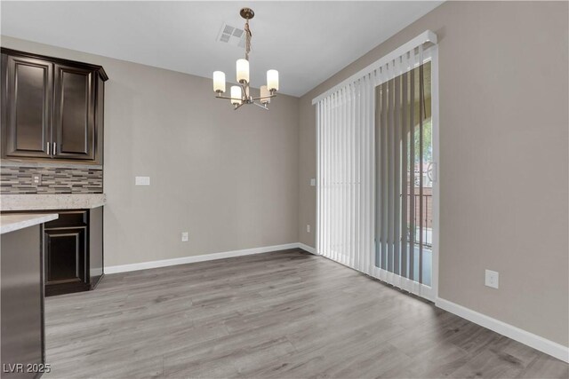 8520 Insignia Ave Unit 104, Las Vegas, NV 89178 - unfurnished dining area featuring a chandelier and light wood-style floors