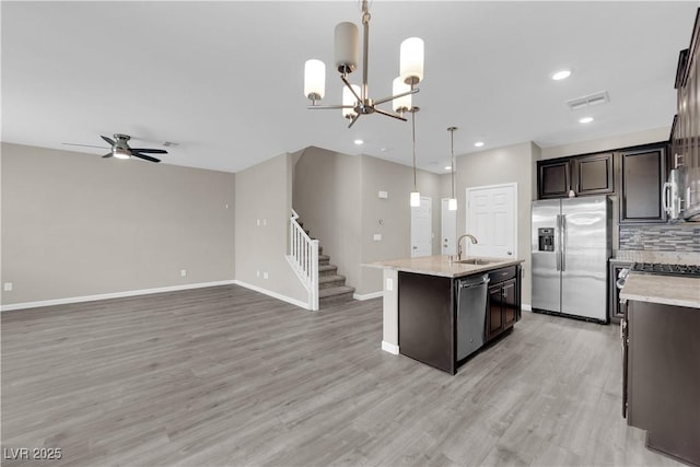 8520 Insignia Ave Unit 104, Las Vegas, NV 89178 - kitchen featuring appliances with stainless steel finishes, an island with sink, dark brown cabinets, open floor plan, and light wood-type flooring