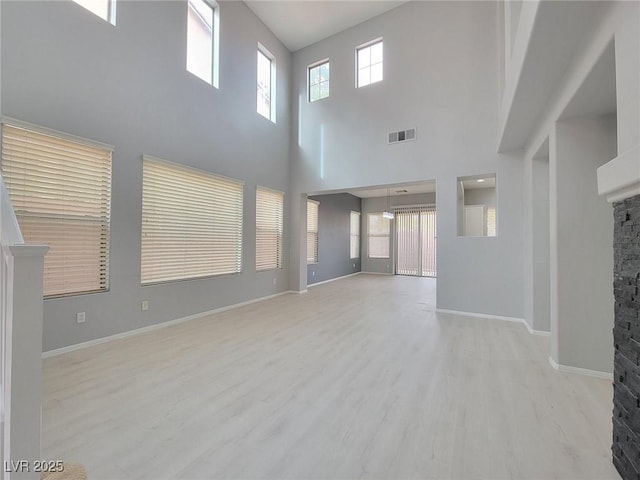 10482 Calico Pines Ave, Las Vegas, NV 89135 - unfurnished living room with a stone fireplace, wood finished floors, and a towering ceiling