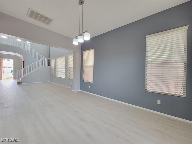 10482 Calico Pines Ave, Las Vegas, NV 89135 - unfurnished room featuring wood finished floors, arched walkways, and stairway