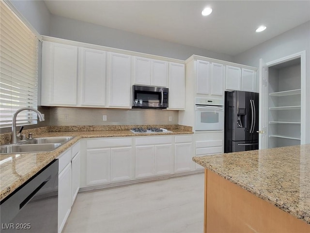 10482 Calico Pines Ave, Las Vegas, NV 89135 - kitchen featuring white appliances, white cabinets, light stone countertops, and recessed lighting