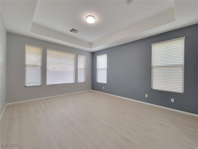 10482 Calico Pines Ave, Las Vegas, NV 89135 - unfurnished room with a tray ceiling and wood finished floors