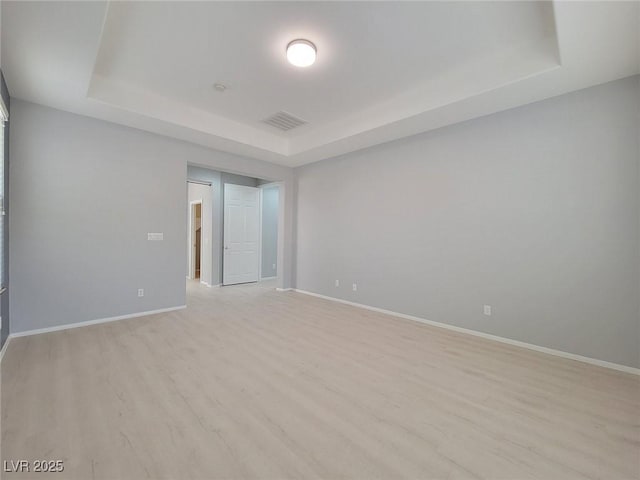 10482 Calico Pines Ave, Las Vegas, NV 89135 - empty room with a tray ceiling and light wood-style flooring