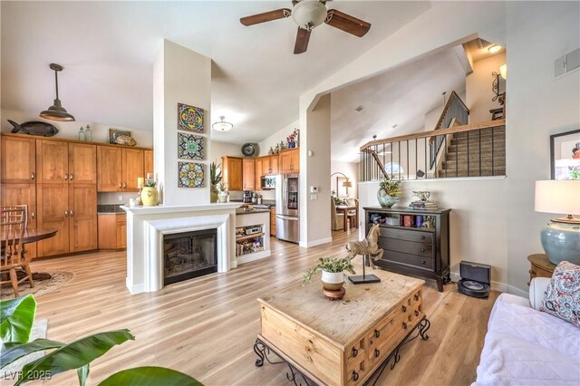 3324 Canyon Lake Dr, Las Vegas, NV 89117 - living room featuring ceiling fan, stairs, high vaulted ceiling, and light wood-style flooring